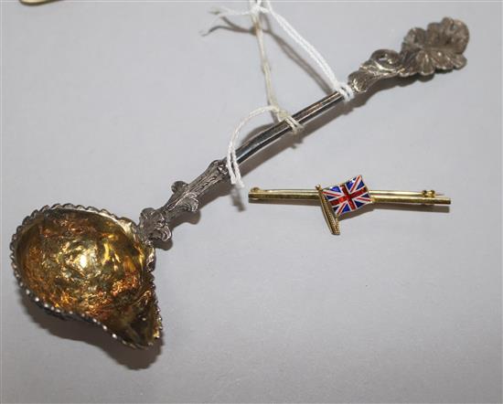 An ornate Victorian silver cream ladle by G.f. Pinell, London, 1846 and a 9ct. gold and enamel Union Jack bar brooch.